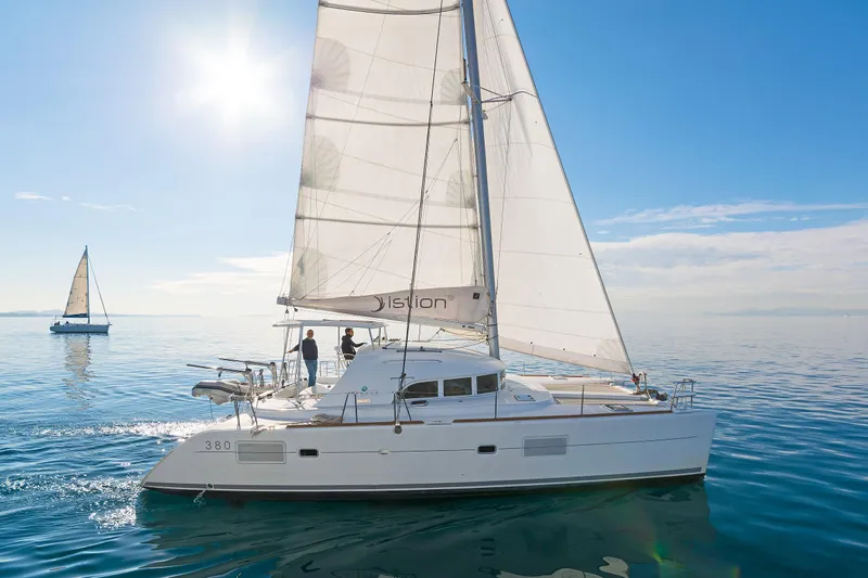 Cataki Yacht Photos Pics 2017 Lagoon 380 S2 catamaran sailing on calm ocean under clear blue sky.