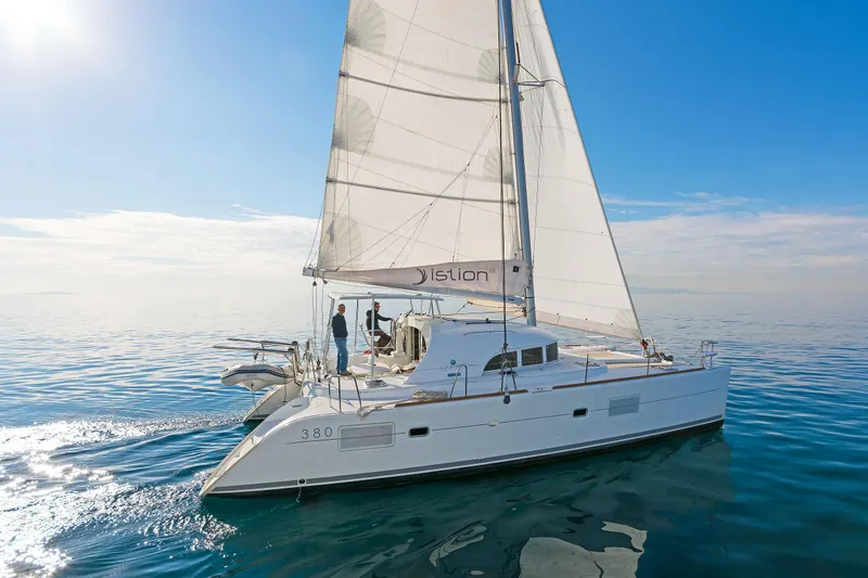Cataki Yacht Photos Pics Sailing catamaran Lagoon 380 S2, 2017 model, gliding on calm blue waters under clear skies.