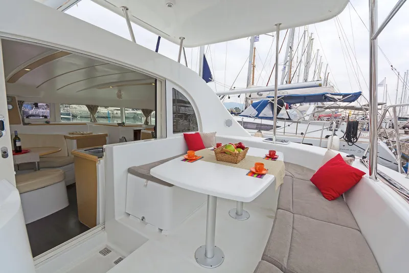 Cataki Yacht Photos Pics 2017 Lagoon 380 S2 yacht interior with cozy seating and dining area in marina.