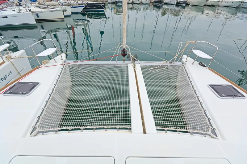 Cataki Yacht Photos Pics 2017 Lagoon 380 S2 catamaran with netted deck, docked in a marina.