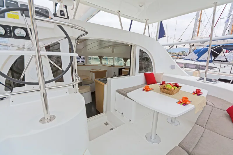 Cataki Yacht Photos Pics Lagoon 380 S2 2017 catamaran interior with dining area, helm, and cozy seating.