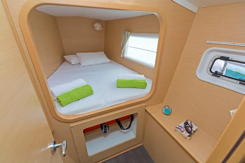 Cataki Yacht Photos Pics Cozy cabin interior of 2017 Lagoon 380 S2 catamaran with bed and porthole.