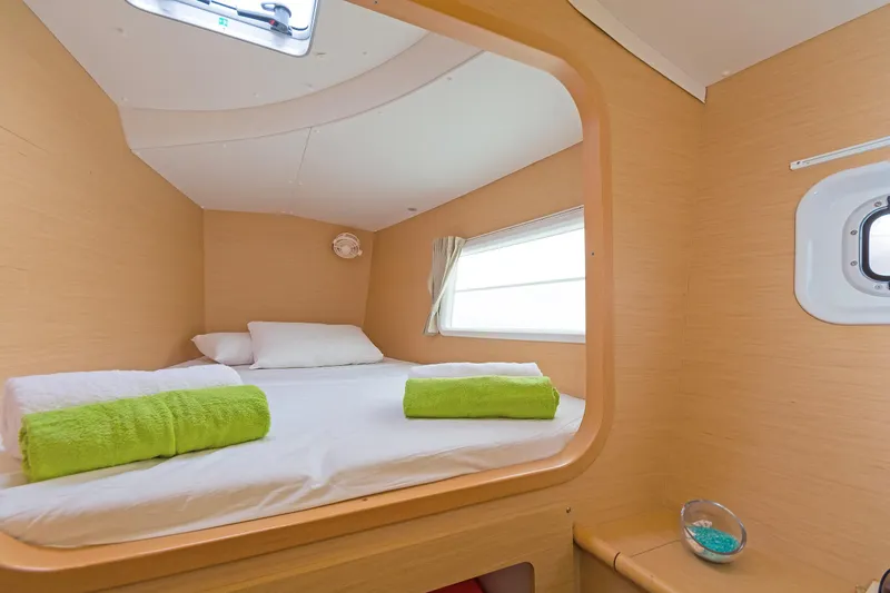 Cataki Yacht Photos Pics Cozy cabin interior of 2017 Lagoon 380 S2 with bed and porthole window.