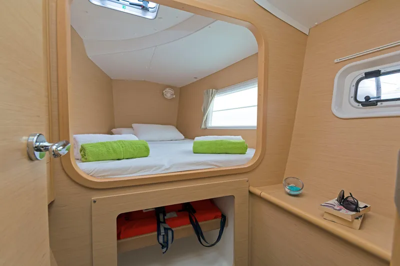 Cataki Yacht Photos Pics Cozy cabin interior of 2017 Lagoon 380 S2 catamaran with bed and porthole window.