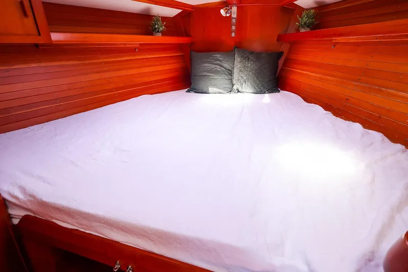 Hamburg II Yacht Photos Pics Cozy cabin interior of 2002 J Boats J/46 with wooden paneling and comfortable bedding.