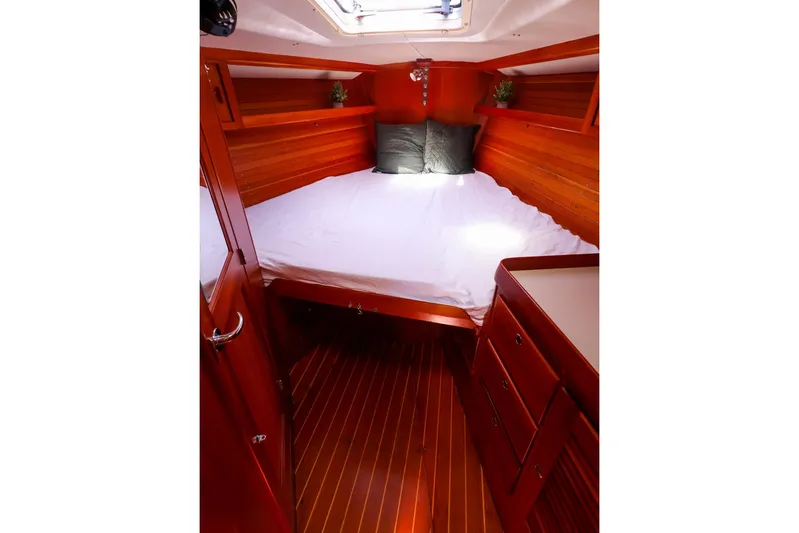 Hamburg II Yacht Photos Pics Luxurious cabin interior of 2002 J Boats J/46 with wooden finish and cozy bedding.