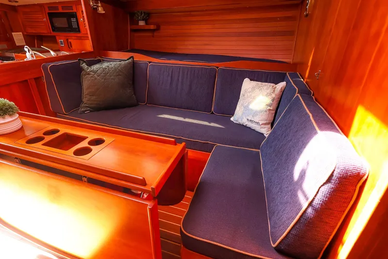 Hamburg II Yacht Photos Pics Luxurious interior of 2002 J Boats J/46 yacht with cozy seating and elegant wood finish.