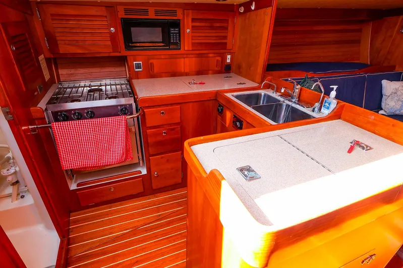 Hamburg II Yacht Photos Pics Luxurious 2002 J Boats J/46 yacht interior with wooden cabinetry and modern kitchen amenities.