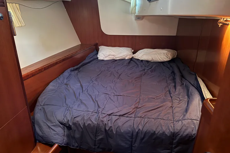 Lumiere Yacht Photos Pics Cozy cabin interior of 2007 Beneteau 49 yacht with double bed and wooden finish.