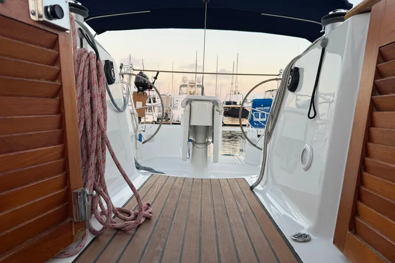 Lumiere Yacht Photos Pics Cockpit view of 2007 Beneteau 49 sailboat with wooden deck and marina background.