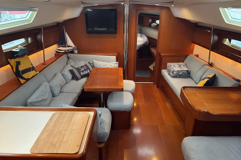 Lumiere Yacht Photos Pics Luxurious interior of 2007 Beneteau 49 yacht with cozy seating and elegant wood finish.