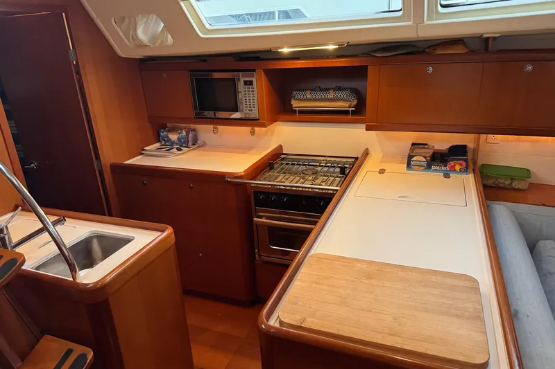 Lumiere Yacht Photos Pics Interior of 2007 Beneteau 49 yacht kitchen with stove, microwave, and sink.