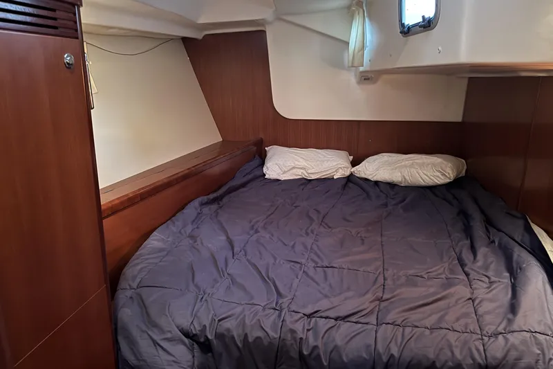 Lumiere Yacht Photos Pics Cozy cabin interior of 2007 Beneteau 49 yacht with double bed and wooden paneling.