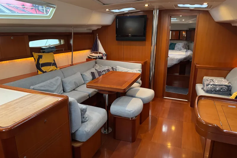 Lumiere Yacht Photos Pics Luxurious interior of a 2007 Beneteau 49 yacht with cozy seating and elegant wood finishes.