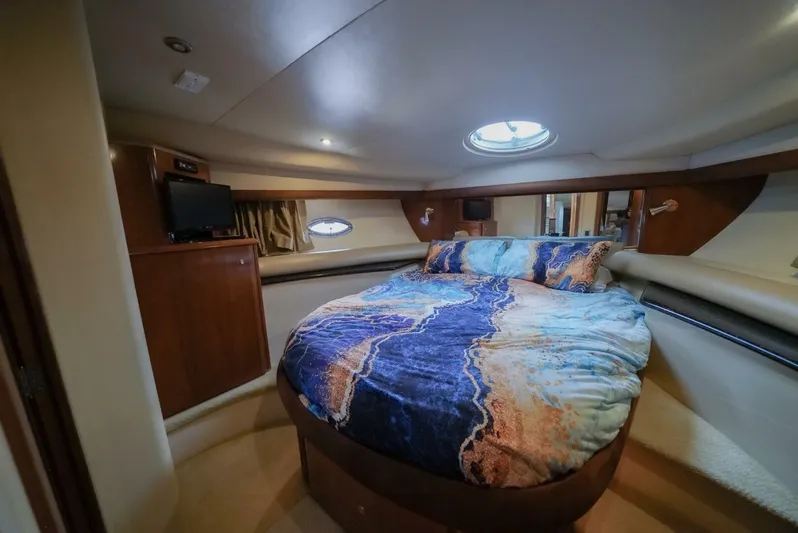 Poseidon's Mistress Yacht Photos Pics Luxurious bedroom in a 2007 Meridian 459 Motor Yacht with a cozy bed and porthole windows.
