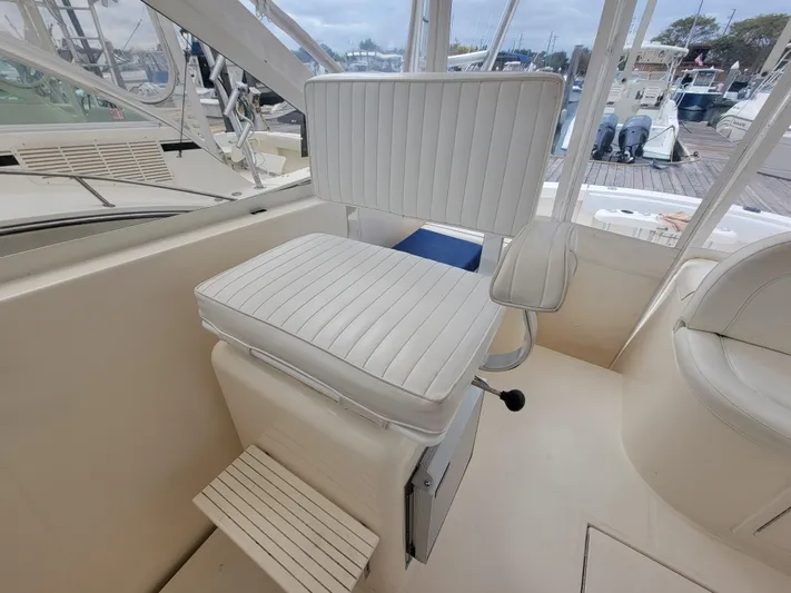  Yacht Photos Pics Captain's chair on 2006 Carolina Classic 32 Express boat, featuring white upholstery and footrest.