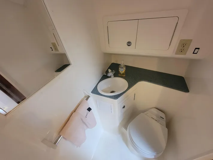  Yacht Photos Pics 2006 Carolina Classic 32 Express bathroom with sink, toilet, and storage cabinets.