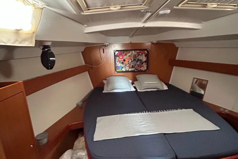 Pau Hana Yacht Photos Pics Cozy cabin interior of 2007 Beneteau Cyclades 50.3 sailboat with double bed and artwork.