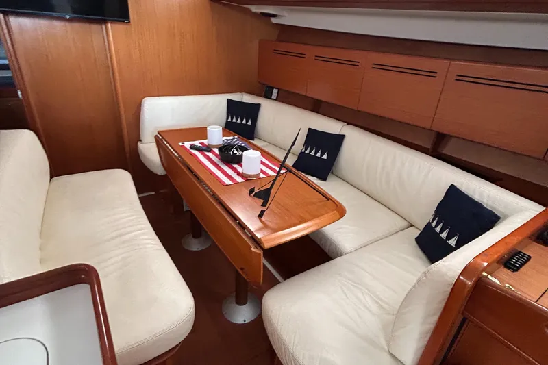 Pau Hana Yacht Photos Pics Interior of 2007 Beneteau Cyclades 50.3 yacht with cozy seating and wooden table.