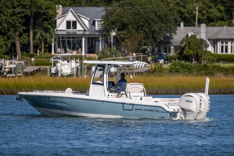  Yacht Photos Pics 2024 Sea Hunt Escape 28 boat cruising on a scenic waterway near waterfront homes.