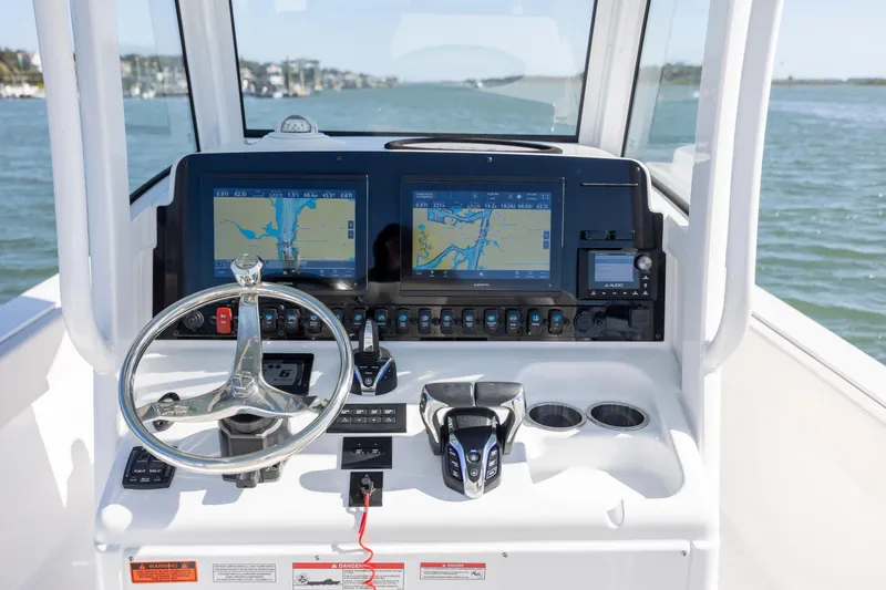  Yacht Photos Pics 2024 Sea Hunt Escape 28 boat dashboard with navigation screens and steering wheel.