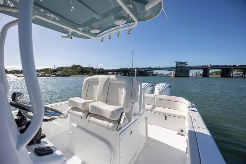  Yacht Photos Pics 2024 Sea Hunt Escape 28 boat on water near a bridge, featuring dual engines and seating.