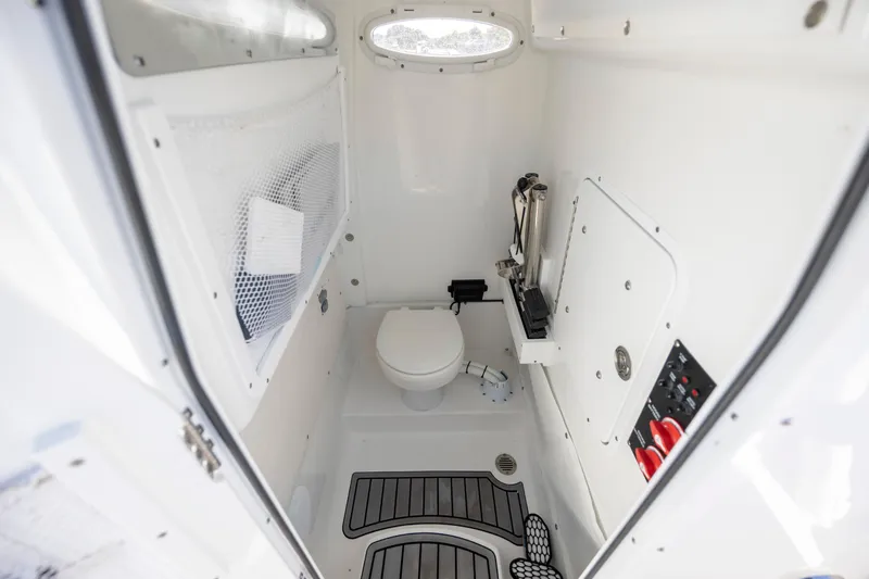  Yacht Photos Pics 2024 Sea Hunt Escape 28 boat interior with compact marine toilet and storage.