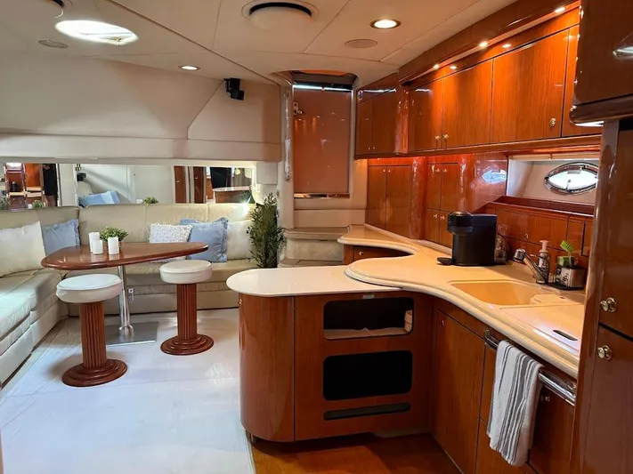  Yacht Photos Pics Luxurious interior of 2000 Sea Ray 510 Sundancer yacht with elegant wood cabinetry and cozy seating.
