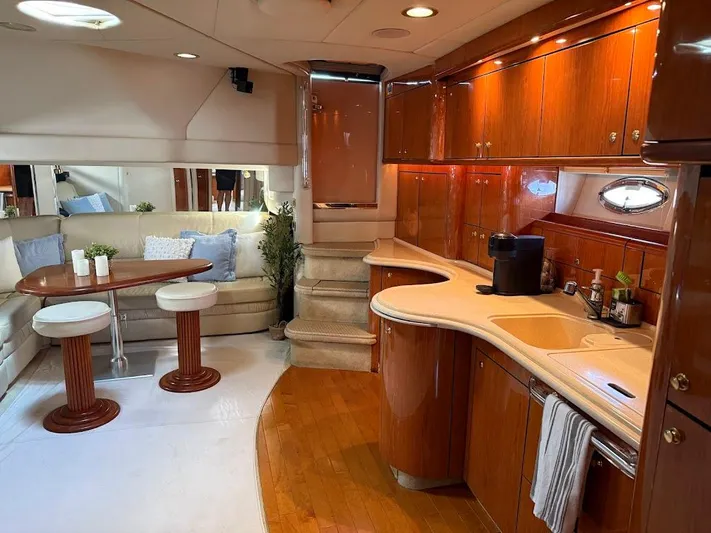  Yacht Photos Pics Luxurious interior of 2000 Sea Ray 510 Sundancer yacht with elegant wood finishes and cozy seating.