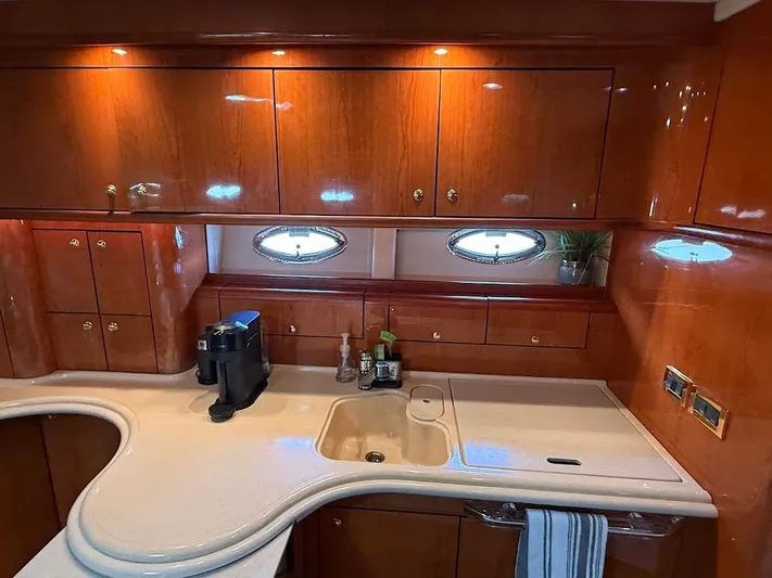 Yacht Photos Pics Luxurious kitchen interior of 2000 Sea Ray 510 Sundancer yacht with wooden cabinets and modern amenities.