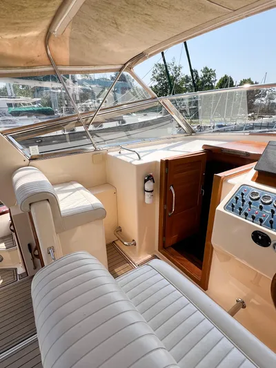 A'maure Yacht Photos Pics 2001 Apreamare 11 yacht cockpit with white seating, wooden accents, and control panel.
