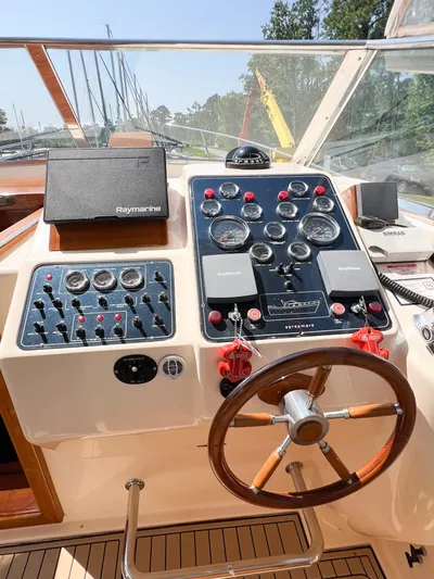 A'maure Yacht Photos Pics Control panel of a 2001 Apreamare 11 boat with steering wheel and navigation instruments.