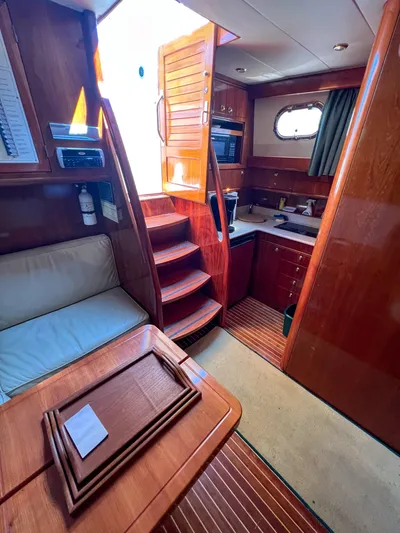 A'maure Yacht Photos Pics Interior of 2001 Apreamare 11 yacht, featuring wooden cabinetry and compact kitchen area.