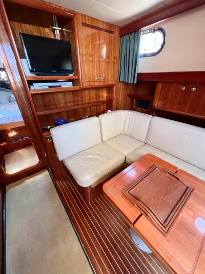 A'maure Yacht Photos Pics Interior of 2001 Apreamare 11 yacht with wooden finish and cozy seating area.