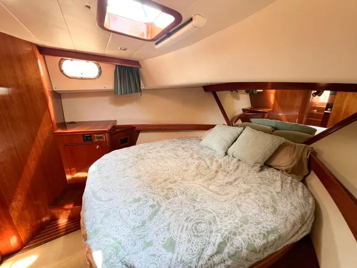 A'maure Yacht Photos Pics Luxurious cabin interior of 2001 Apreamare 11 yacht with cozy bed and wooden accents.