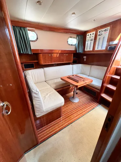 A'maure Yacht Photos Pics Luxurious interior of a 2001 Apreamare 11 yacht with elegant wood finishes and cozy seating.