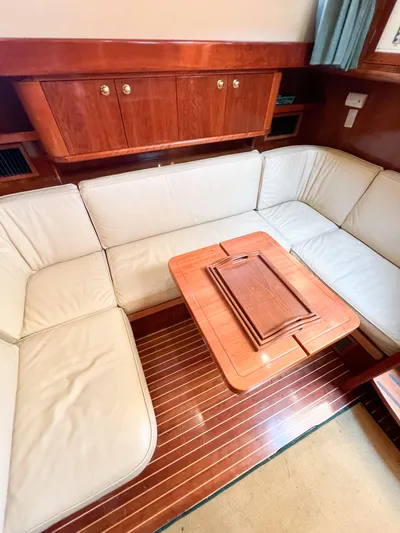 A'maure Yacht Photos Pics Luxurious interior of 2001 Apreamare 11 yacht with cream seating and wooden table.