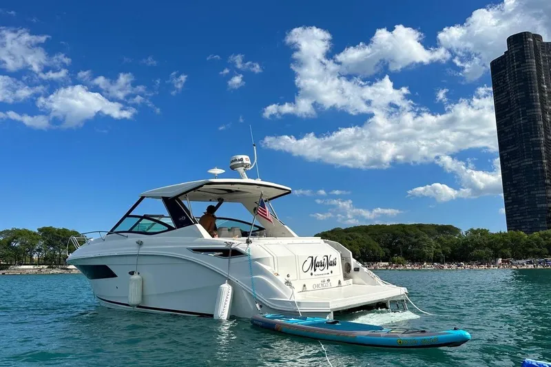  Yacht Photos Pics 2019 Sea Ray Sundancer 320 yacht on water, clear sky, cityscape background.