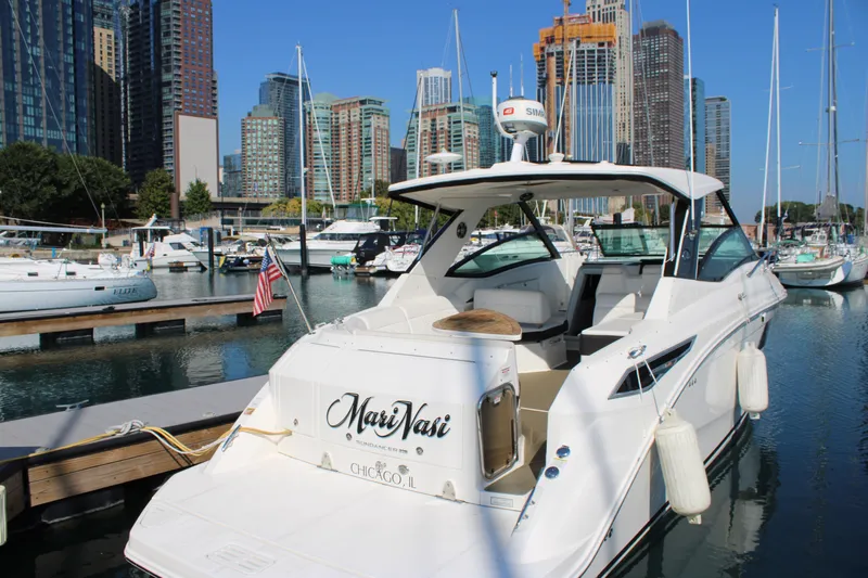  Yacht Photos Pics 2019 Sea Ray Sundancer 320 docked in a marina with city skyline backdrop.