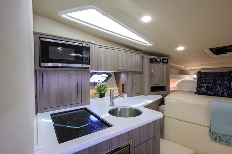 Damn Daddy Yacht Photos Pics 2020 Regal 35 Sport Coupe interior with modern kitchen and cozy sleeping area.