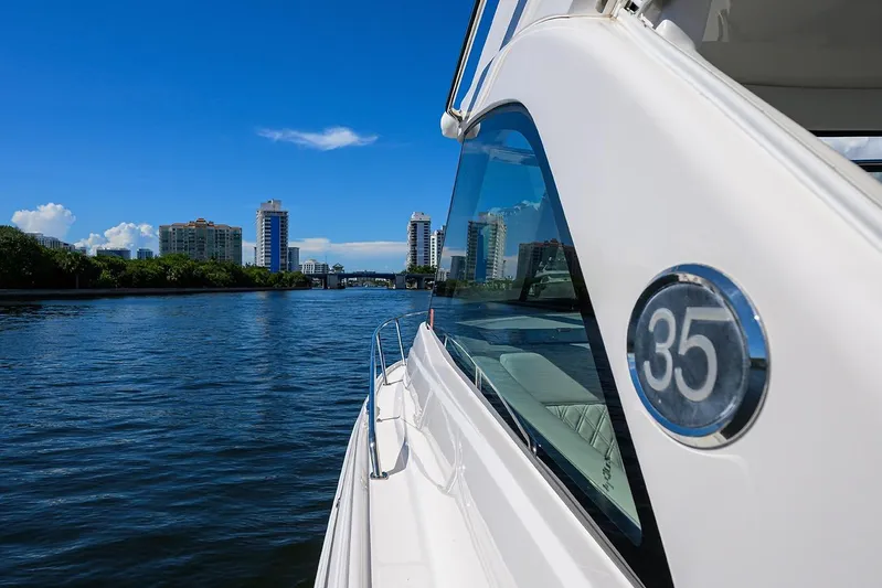 Damn Daddy Yacht Photos Pics 2020 Regal 35 Sport Coupe cruising on a sunny day with city skyline.