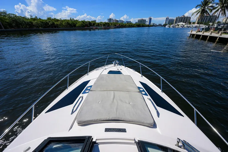 Damn Daddy Yacht Photos Pics 2020 Regal 35 Sport Coupe cruising on a sunny waterway with city skyline.