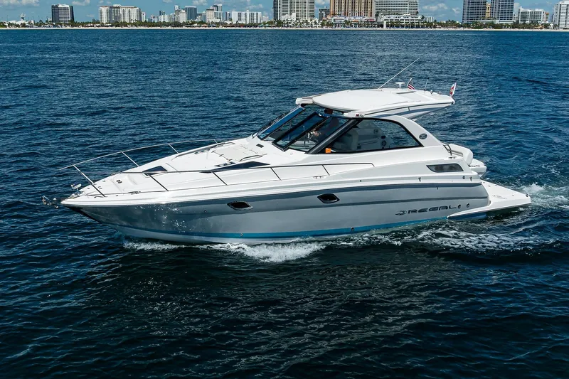 Damn Daddy Yacht Photos Pics 2020 Regal 35 Sport Coupe cruising on open water near city skyline.
