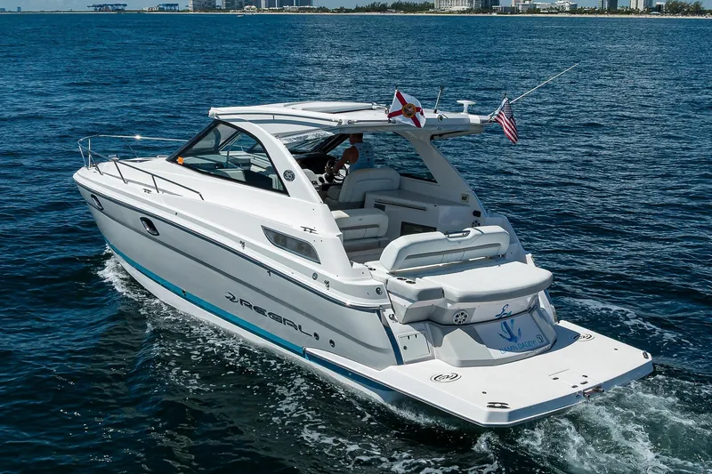 Damn Daddy Yacht Photos Pics 2020 Regal 35 Sport Coupe cruising on open water, rear view.
