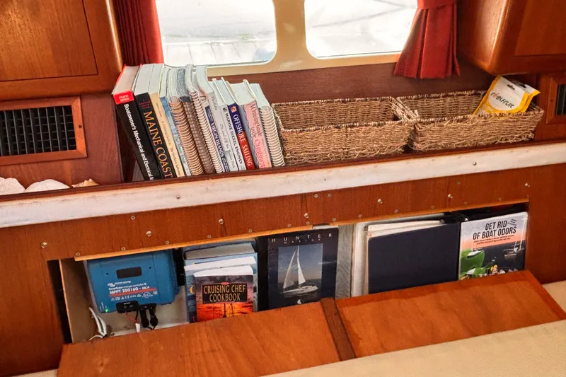 Orion Yacht Photos Pics Interior of 2002 Hunter 410 sailboat with books and wicker baskets on wooden shelves.