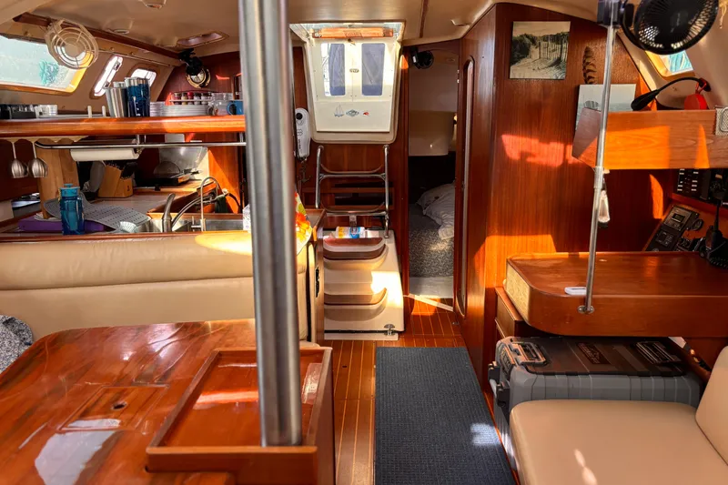 Orion Yacht Photos Pics Interior of a 2002 Hunter 410 sailboat, featuring wood finishes and cozy seating.