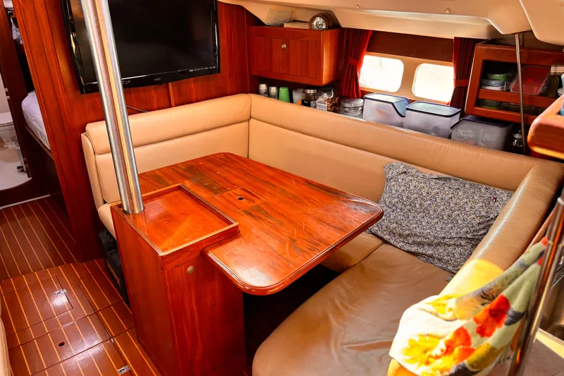 Orion Yacht Photos Pics Cozy interior of 2002 Hunter 410 sailboat with wooden table and beige seating.