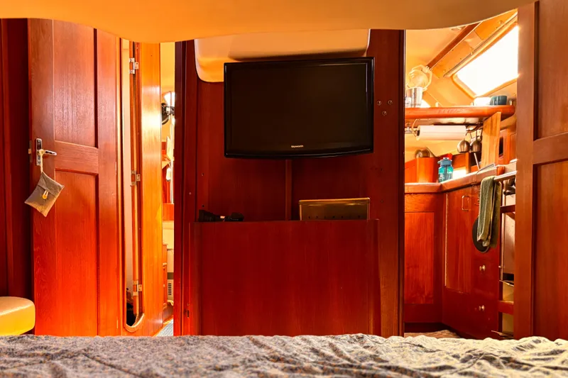 Orion Yacht Photos Pics Interior of a 2002 Hunter 410 sailboat with wooden cabinetry and a mounted TV.