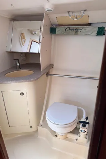 Orion Yacht Photos Pics Compact bathroom in 2002 Hunter 410 sailboat with sink, toilet, and storage.
