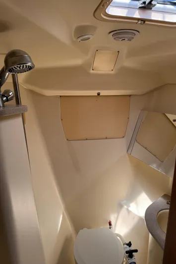 Orion Yacht Photos Pics 2002 Hunter 410 boat bathroom with showerhead, toilet, and mirror.